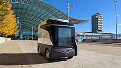 Autonomous shuttle vehicle parked outside the airport terminal on a sunny day