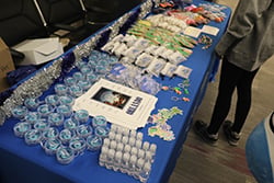 Table displaying gift bags, candles, and event swag items