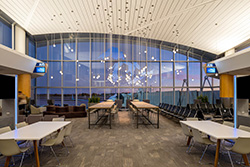 Interior view of an airport lounge seating area with string lighting