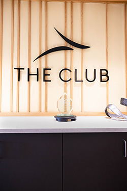 "The Club" lounge reception sign with an award display