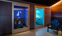Interior of a sensory room with two illuminated doorways and a bench