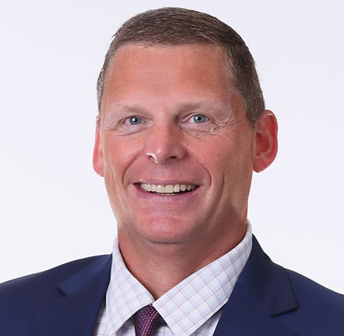 Professional headshot portrait of Tory Richardson in a navy suit